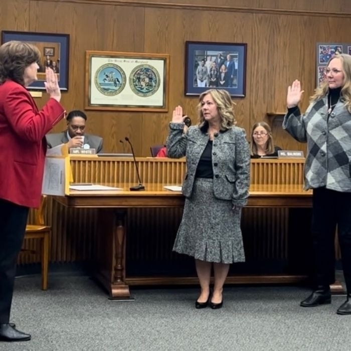 Lisa Grenis and Jana Post raising their right hands while being sworn in to the Calvert County Board of Education